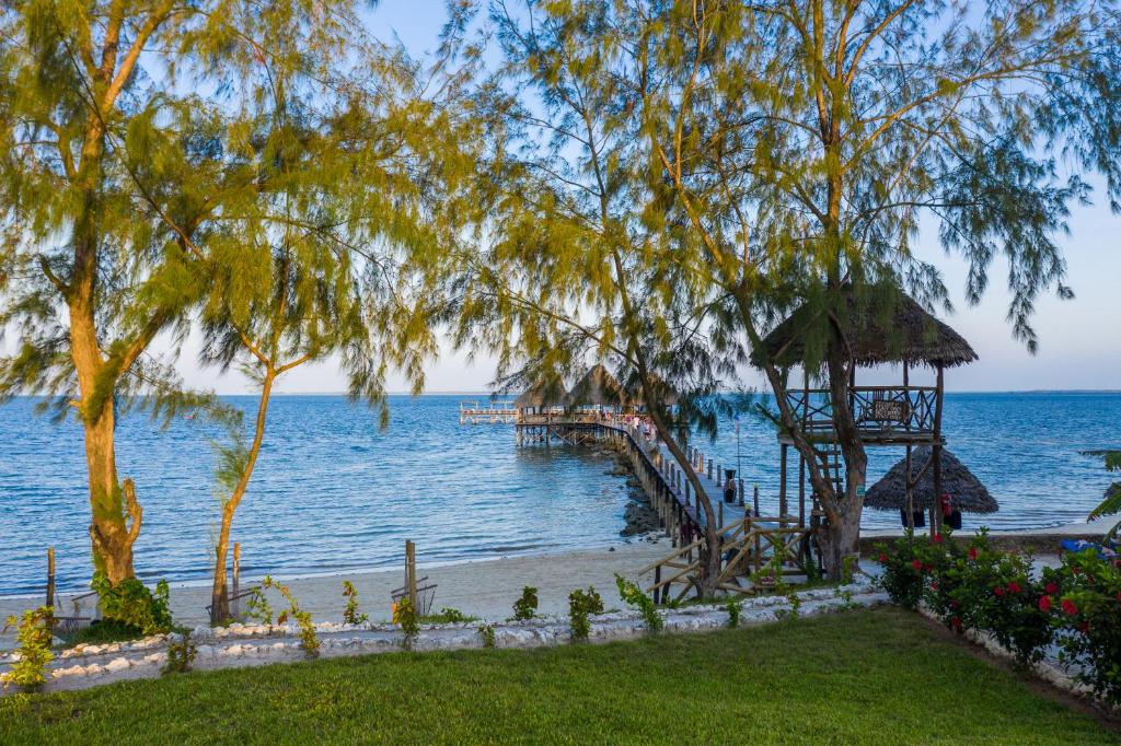 Wooden jetty stretching into turquoise ocean at Zanzibar Bay Resort beach